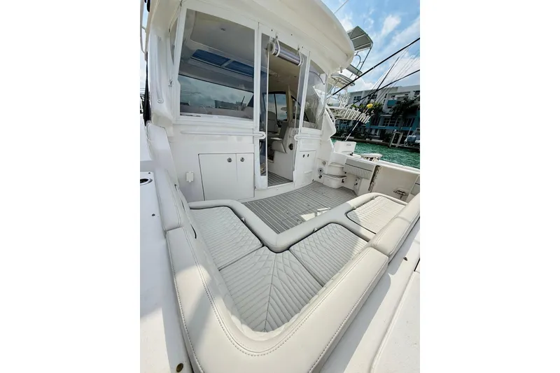 Slide: The Image of 2021 Intrepid 410 Evolution boat interior with cushioned seating and sleek design. - 16