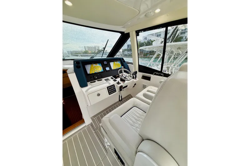 Slide: The Image of 2021 Intrepid 410 Evolution yacht helm with modern navigation displays and luxurious seating. - 28