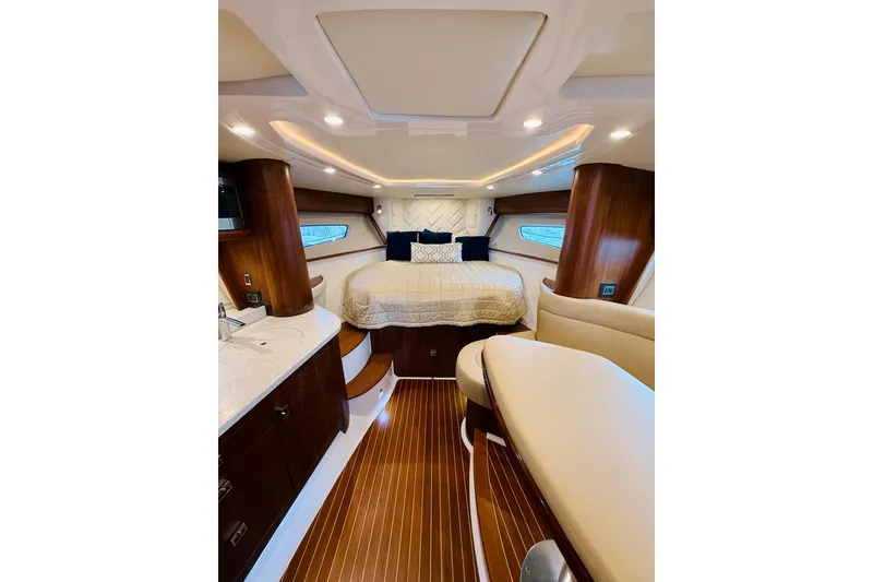 Slide: The Image of Luxurious interior of 2021 Intrepid 410 Evolution yacht with elegant wood finishes and cozy bedding. - 37