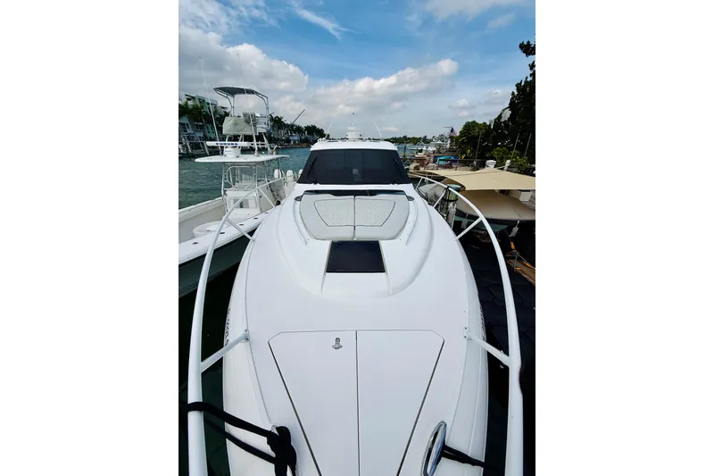 Slide: The Image of 2021 Intrepid 410 Evolution yacht docked, showcasing sleek design and spacious deck. - 4