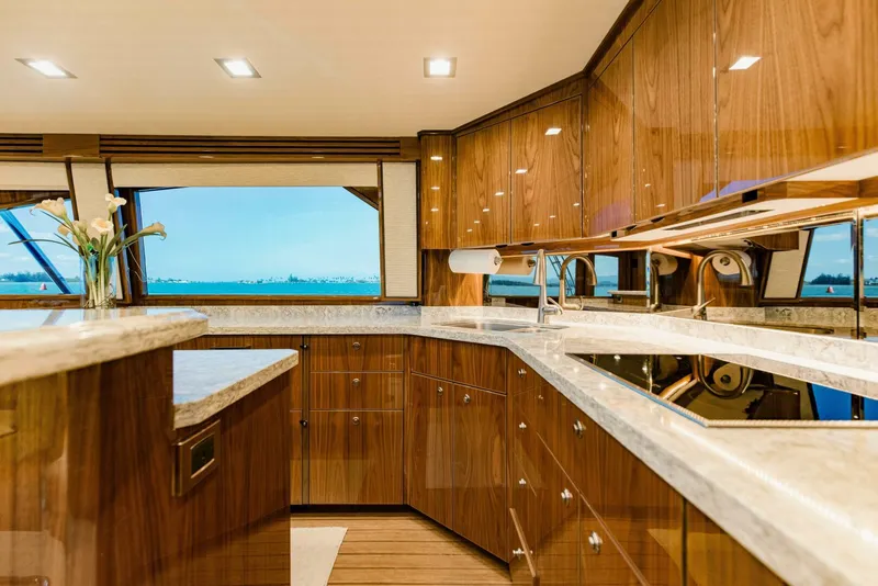 Slide: The Image of Luxurious kitchen interior of 2020 Viking 72 yacht with wooden cabinetry and ocean view. - 12