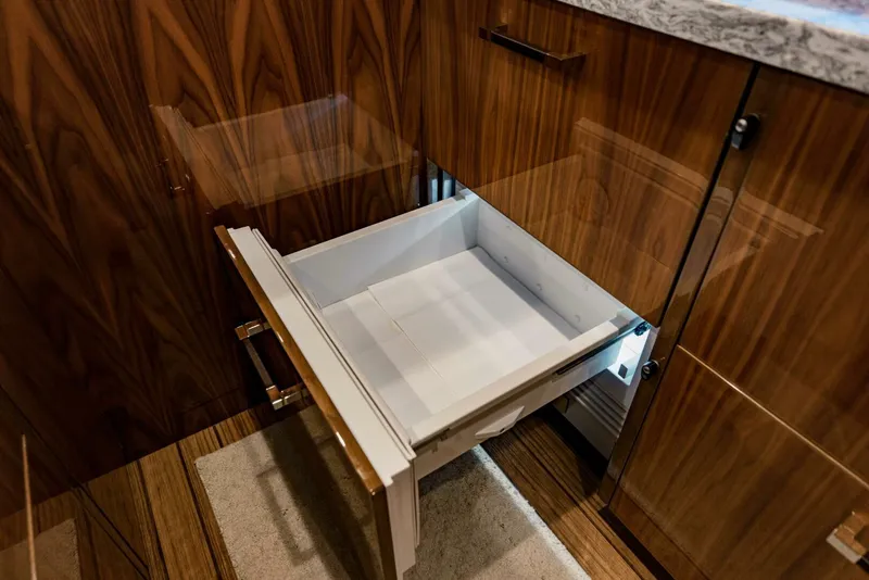 Slide: The Image of Open drawer in a 2020 Viking 72 yacht's wooden cabinetry interior. - 15