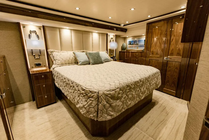 Slide: The Image of Luxurious bedroom interior of 2020 Viking 72 yacht with elegant wood finishes and ambient lighting. - 2