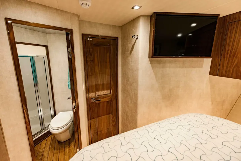 Slide: The Image of Interior of 2020 Viking 72 yacht cabin with bathroom and mounted TV. - 23