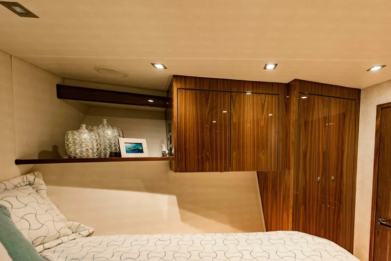 Slide: The Image of Luxurious cabin interior of 2020 Viking 72 yacht with wooden cabinets and cozy bedding. - 25