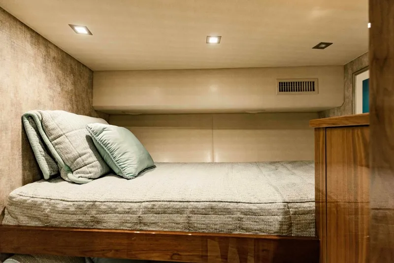 Slide: The Image of Cozy cabin bed in 2020 Viking 72 yacht with soft lighting and plush bedding. - 29