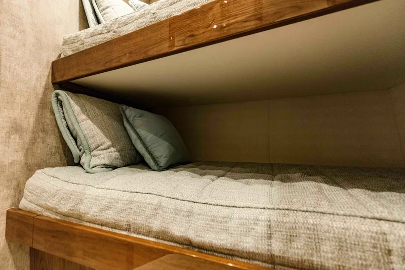 Slide: The Image of Bunk beds in 2020 Viking 72 yacht, featuring cozy bedding and wooden accents. - 30