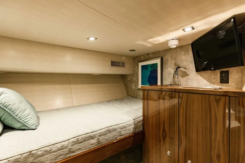 Slide: The Image of Luxurious cabin interior of 2020 Viking 72 yacht with bed, TV, and wooden cabinetry. - 31