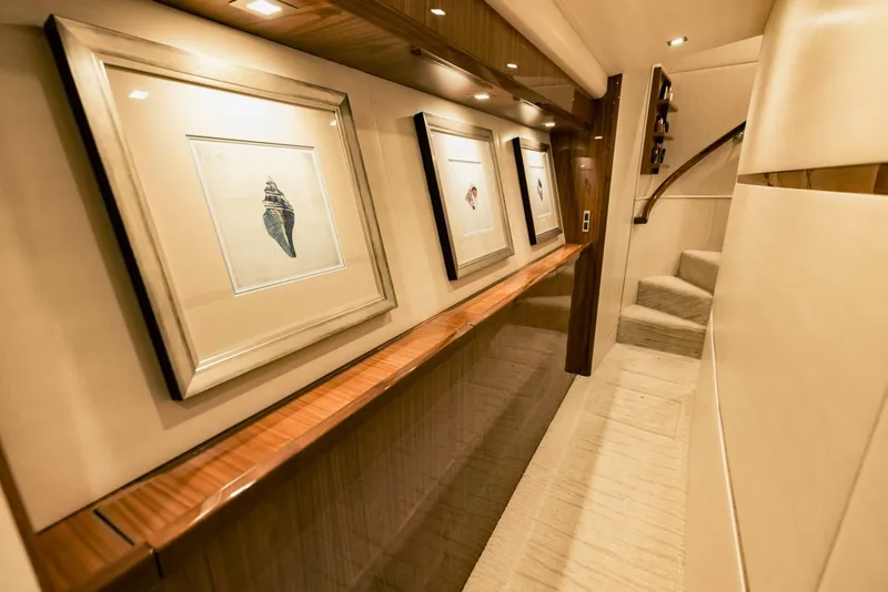 Slide: The Image of Luxurious interior hallway of 2020 Viking 72 yacht with framed artwork and elegant lighting. - 34