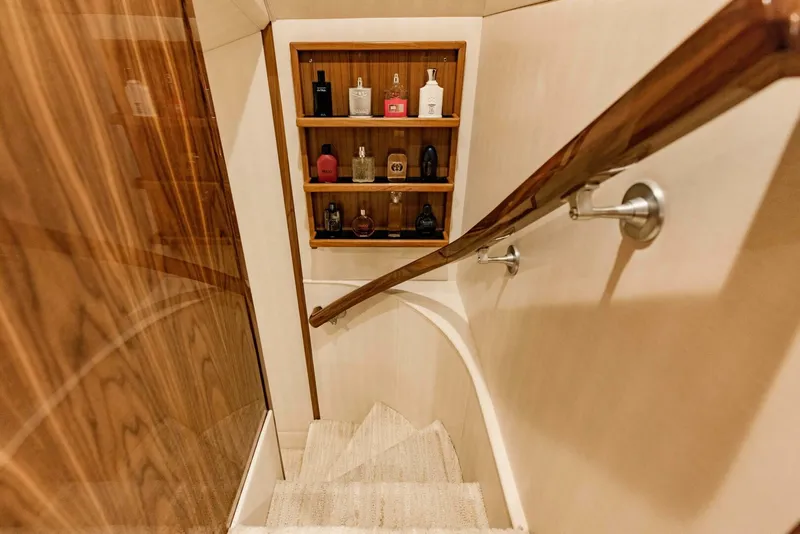 Slide: The Image of Staircase with wooden handrail and shelves on a 2020 Viking 72 yacht interior. - 35