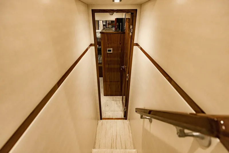 Slide: The Image of Narrow hallway with wooden door and handrail on a 2020 Viking 72 yacht. - 36