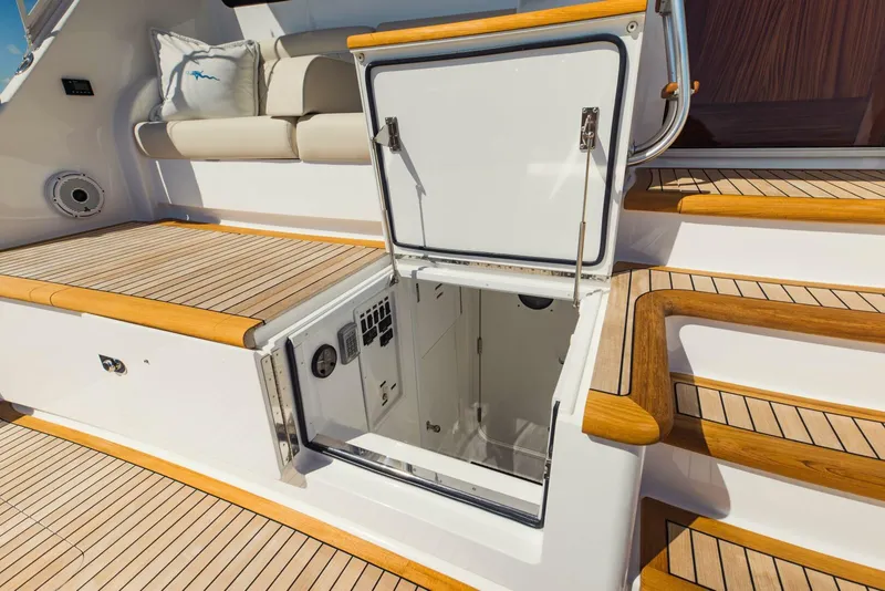 Slide: The Image of 2020 Viking 72 yacht with open hatch, teak deck, and cushioned seating. - 46