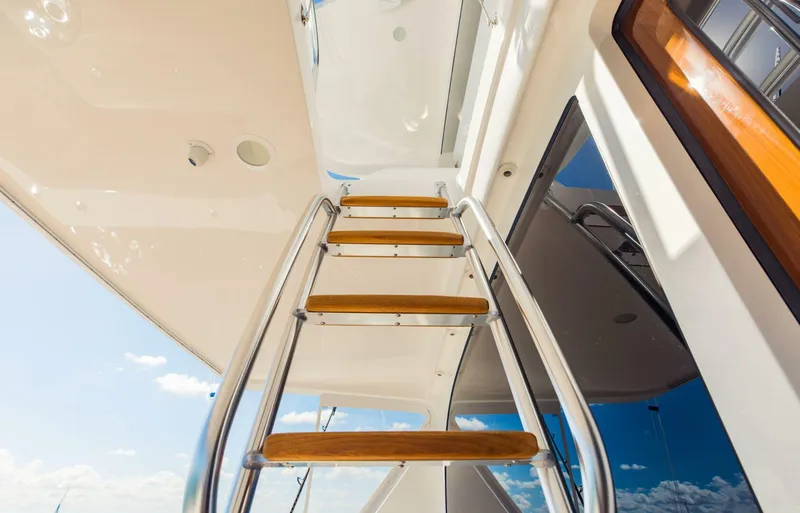 Slide: The Image of Staircase on a 2020 Viking 72 yacht, featuring wooden steps and metal railings. - 47