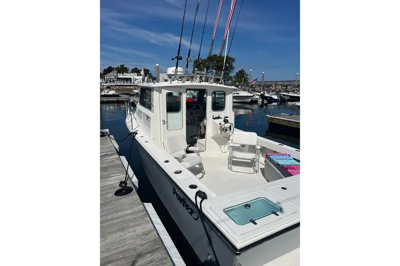 Slide: The Image of 2023 Parker 2520 XLD Sport Cabin boat docked at marina under clear blue sky. - 3