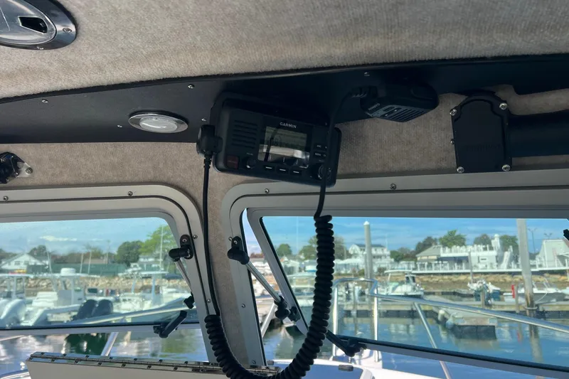 Slide: The Image of Interior of 2023 Parker 2520 XLD Sport Cabin with marine radio and harbor view. - 6