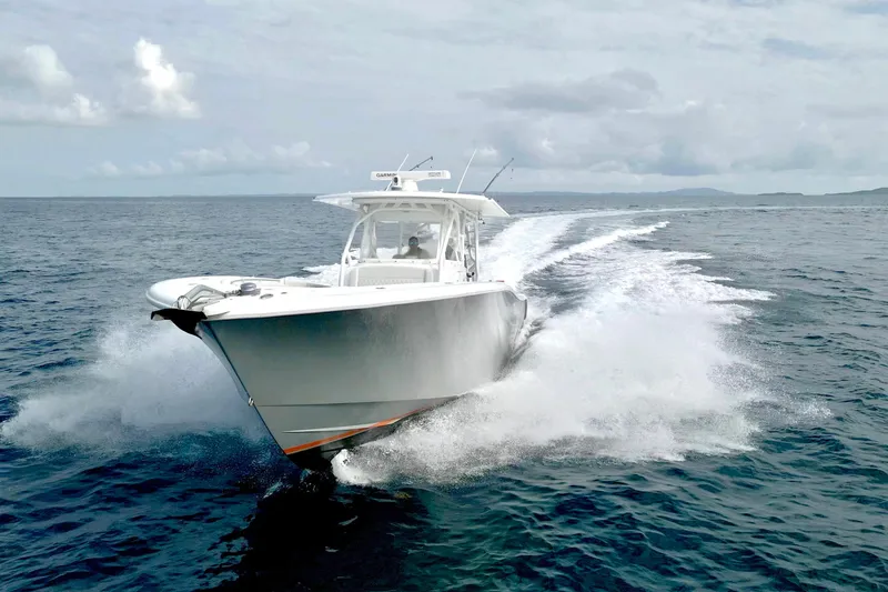 Slide: The Image of 2015 Yellowfin 42 Offshore boat cruising on open water, creating a dynamic wake. - 4