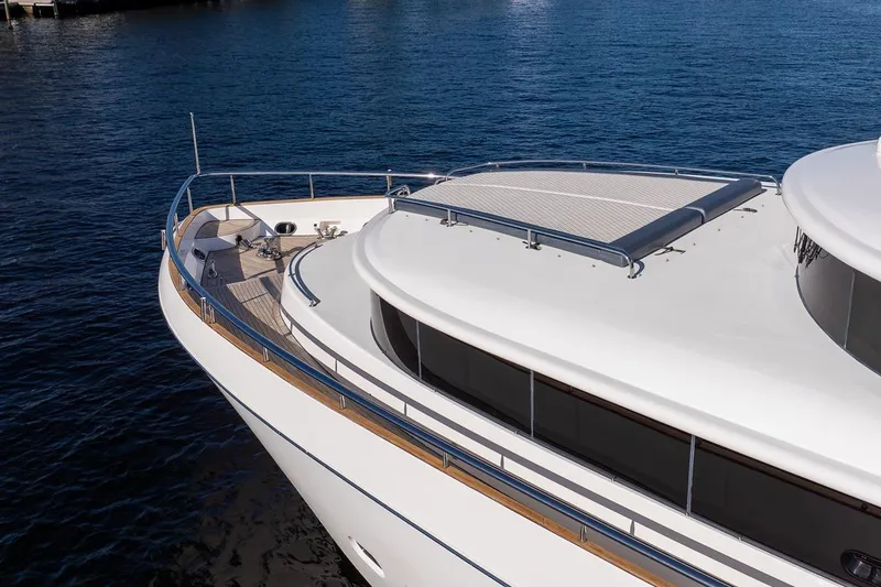 Slide: The Image of 2003 Johnson 87' Motor Yacht on calm blue water, showcasing sleek design and spacious deck. - 10
