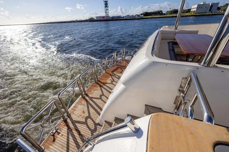 Slide: The Image of 2003 Johnson 87' Motor Yacht cruising on open water, featuring elegant deck design. - 11