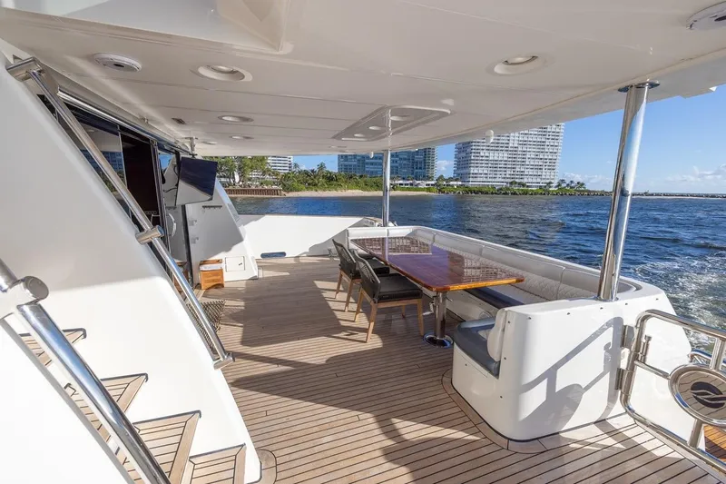 Slide: The Image of Luxurious 2003 Johnson 87' Motor Yacht deck with seating, table, and ocean view. - 13