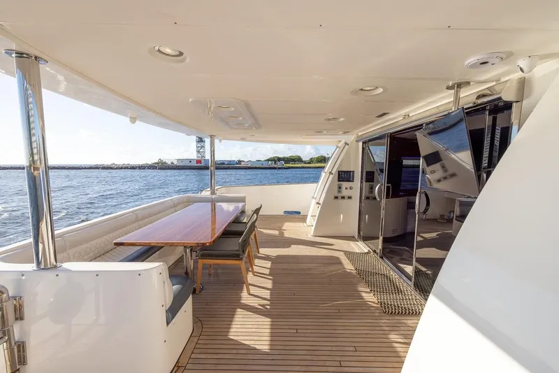 Slide: The Image of Luxurious 2003 Johnson 87' Motor Yacht deck with dining area and ocean view. - 14