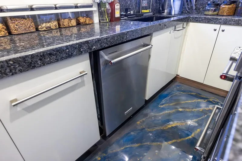 Slide: The Image of Luxurious yacht kitchen with granite countertops, modern appliances, and unique blue-gold flooring. Johnson 87' Motor Yacht 2003. - 38