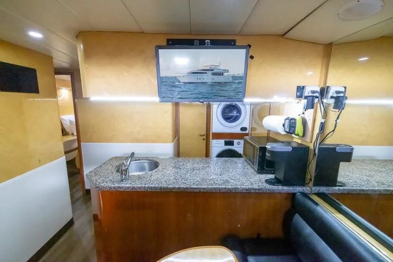 Slide: The Image of Interior of 2003 Johnson 87' Motor Yacht with kitchenette, TV, and laundry appliances. - 68
