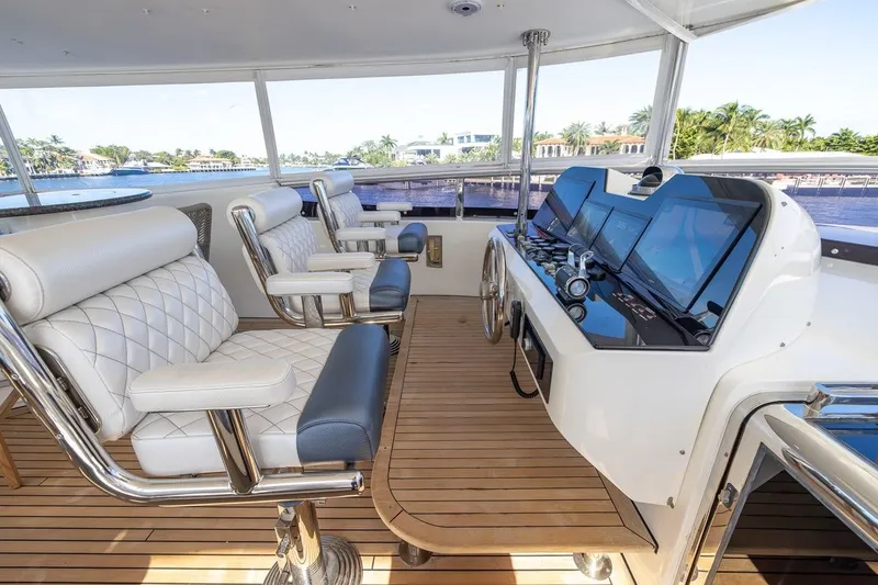 Slide: The Image of Luxurious helm of 2003 Johnson 87' Motor Yacht with plush seating and advanced navigation controls. - 70