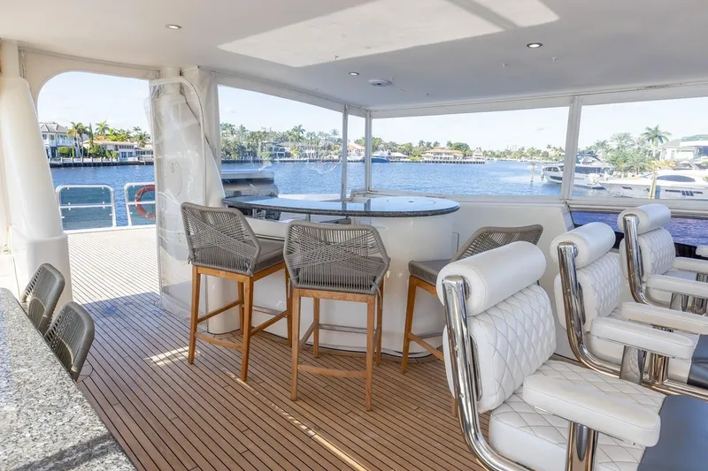 Slide: The Image of Luxurious 2003 Johnson 87' Motor Yacht interior with elegant seating and scenic waterfront view. - 73