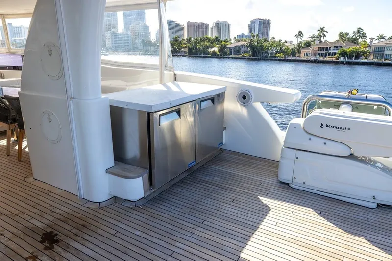 Slide: The Image of Luxurious 2003 Johnson 87' Motor Yacht deck with stainless steel appliances and scenic waterfront view. - 79