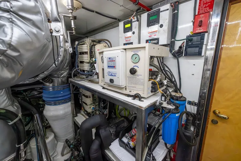 Slide: The Image of Engine room of a 2003 Johnson 87' Motor Yacht with control panels and equipment. - 83