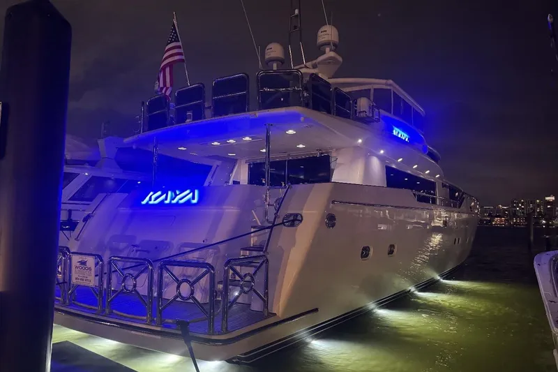 Slide: The Image of Luxurious 2003 Johnson 87' Motor Yacht illuminated at night, docked with city skyline backdrop. - 90