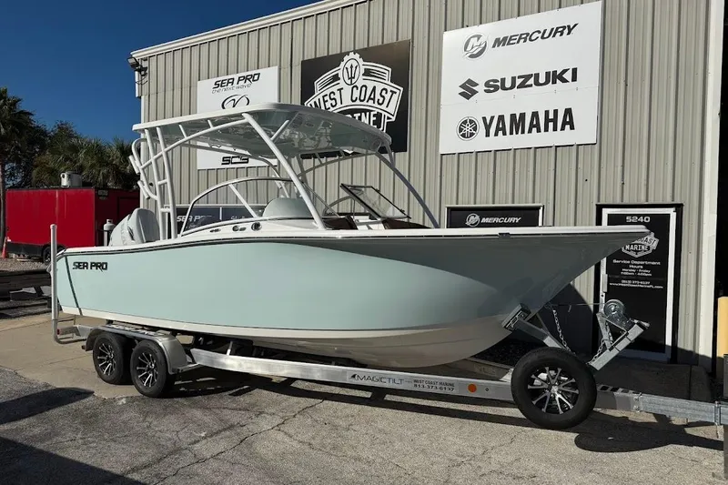 The Image of 2026 Sea Pro 240 Dual Console boat on trailer outside marine dealership. - 1