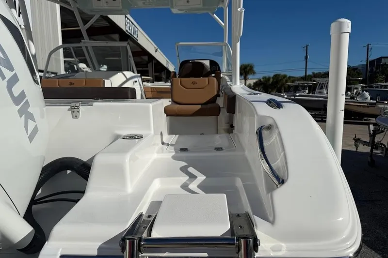 Slide: The Image of 2026 Sea Pro 240 Dual Console boat with Suzuki engine, docked under clear blue sky. - 12