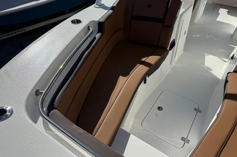 Slide: The Image of 2026 Sea Pro 240 Dual Console boat interior with brown seating and storage compartment. - 16