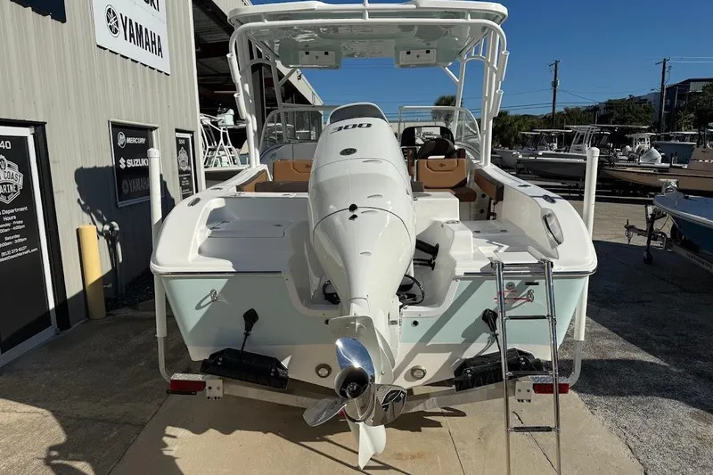 Slide: The Image of 2026 Sea Pro 240 Dual Console boat with powerful outboard motor, docked at a marina. - 8