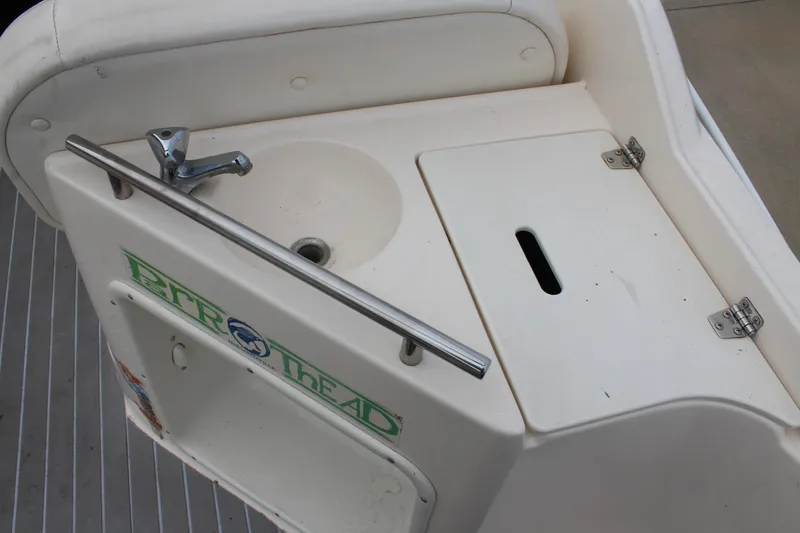 Slide: The Image of 2002 Rinker Fiesta Vee 250 boat sink and storage area with faucet and cover. - 10