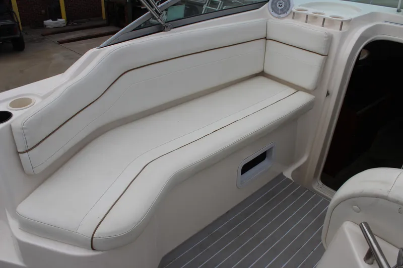 Slide: The Image of 2002 Rinker Fiesta Vee 250 boat interior with white cushioned seating and cup holders. - 12
