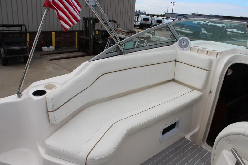 Slide: The Image of 2002 Rinker Fiesta Vee 250 boat interior with white seating and American flag. - 13