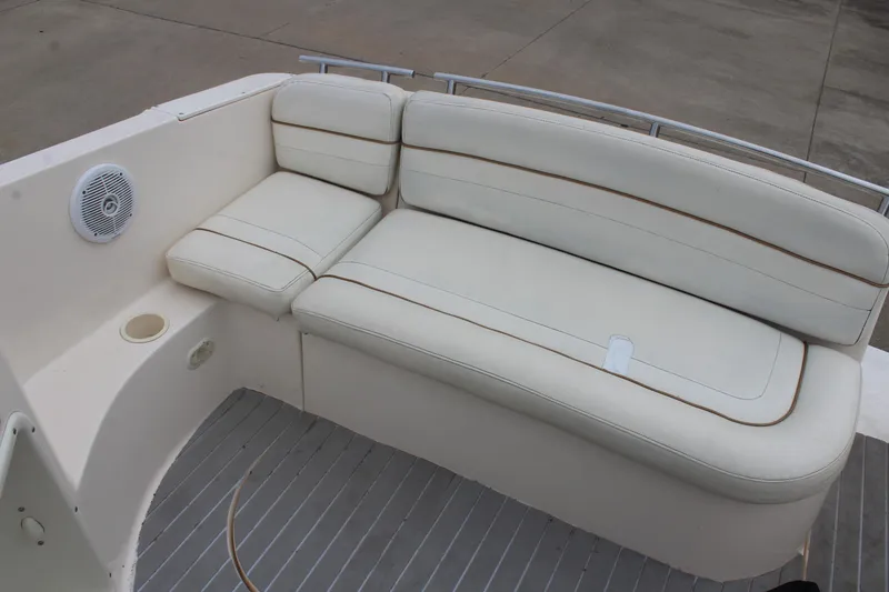 Slide: The Image of 2002 Rinker Fiesta Vee 250 boat interior with white cushioned seating and speaker. - 14