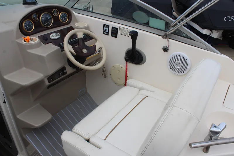 Slide: The Image of 2002 Rinker Fiesta Vee 250 boat cockpit with steering wheel and control panel. - 17