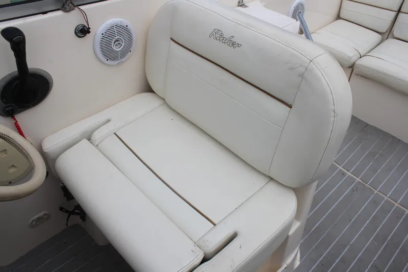 Slide: The Image of 2002 Rinker Fiesta Vee 250 boat interior with white seating and speaker. - 21