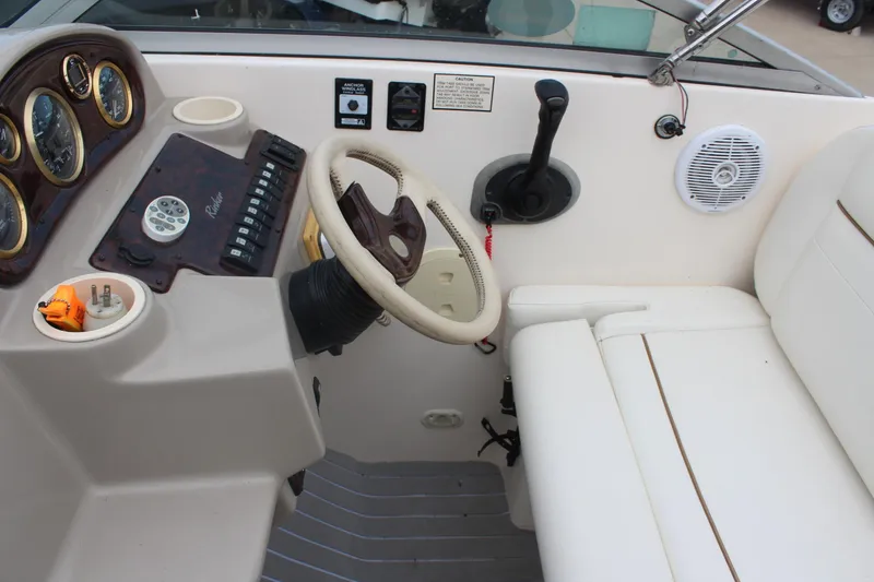 Slide: The Image of 2002 Rinker Fiesta Vee 250 boat cockpit with steering wheel and control panel. - 22