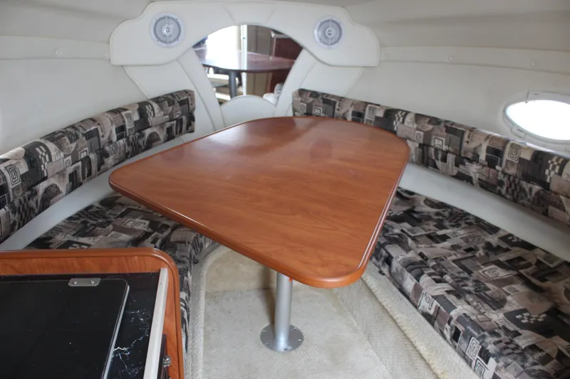 Slide: The Image of Interior of 2002 Rinker Fiesta Vee 250 with wooden table and patterned seating. - 24