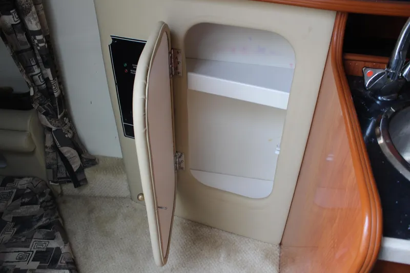 Slide: The Image of 2002 Rinker Fiesta Vee 250 interior cabinet with open door and sink. - 31