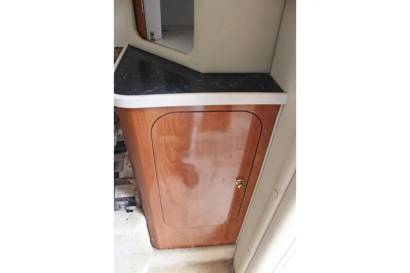 Slide: The Image of 2002 Rinker Fiesta Vee 250 interior cabinet with wood finish and black countertop. - 34