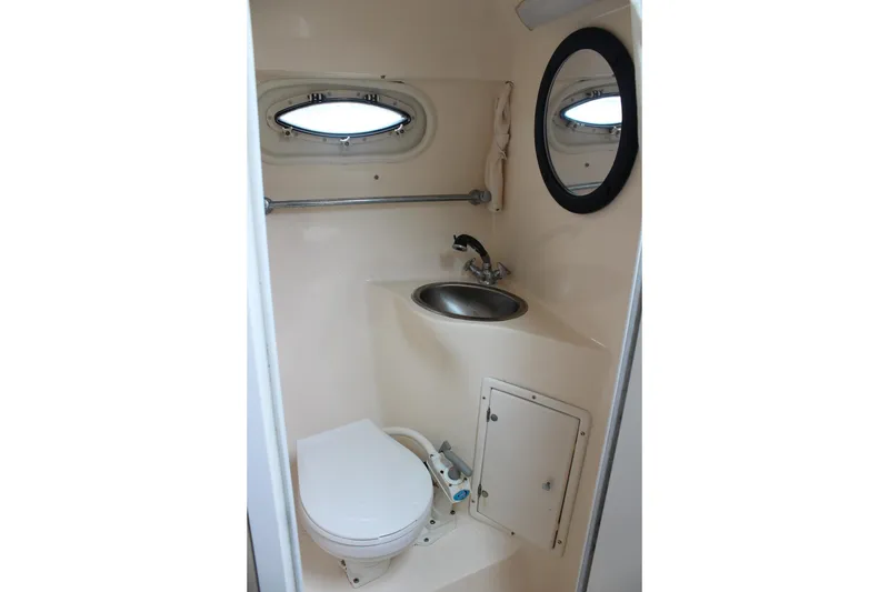 Slide: The Image of 2002 Rinker Fiesta Vee 250 boat bathroom with toilet, sink, and porthole window. - 37