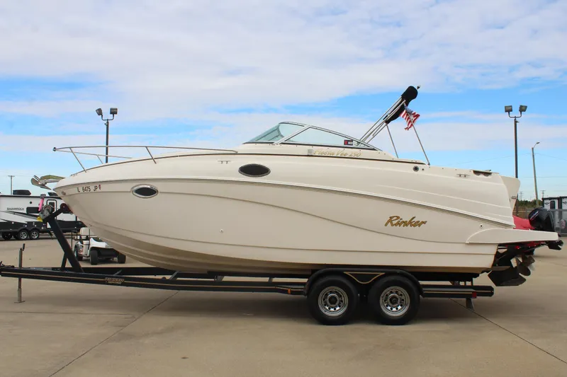 Slide: The Image of 2002 Rinker Fiesta Vee 250 boat on trailer, parked outdoors under cloudy sky. - 4
