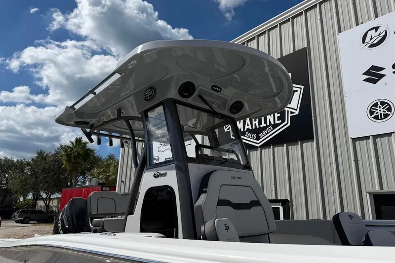 Slide: The Image of 2026 Sea Pro 242 Center Console boat at a marine dealership under a cloudy sky. - 10