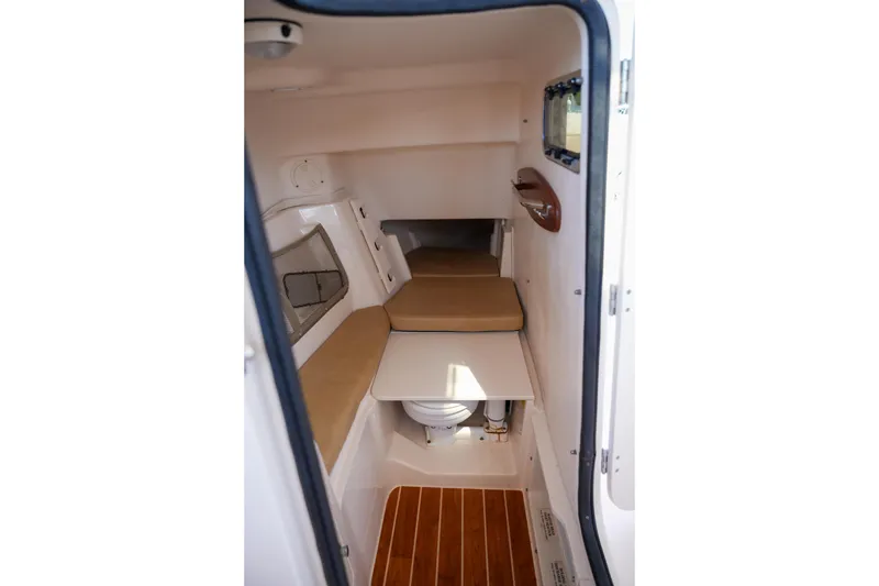 Slide: The Image of 2014 Grady-White Freedom 307 cabin interior with seating and wooden flooring. - 11