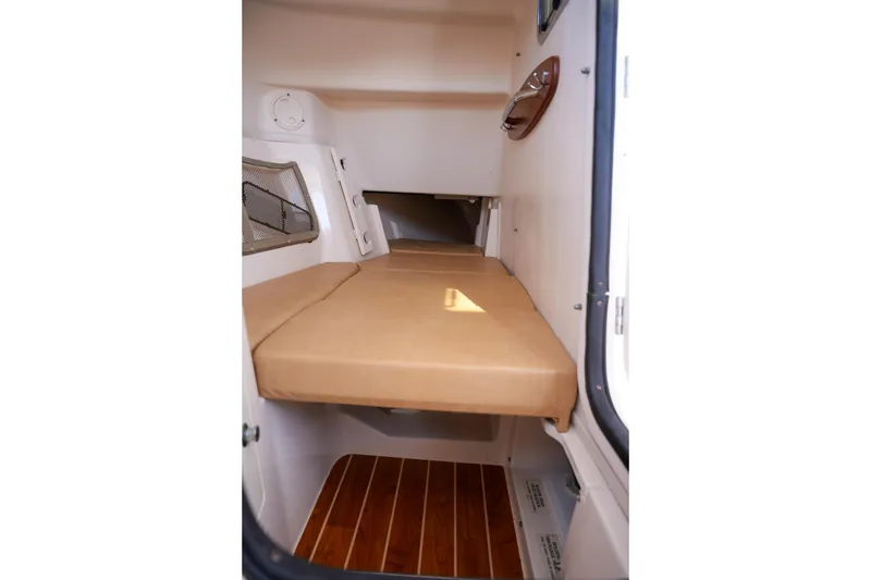Slide: The Image of 2014 Grady-White Freedom 307 cabin interior with cushioned seating and wooden flooring. - 12
